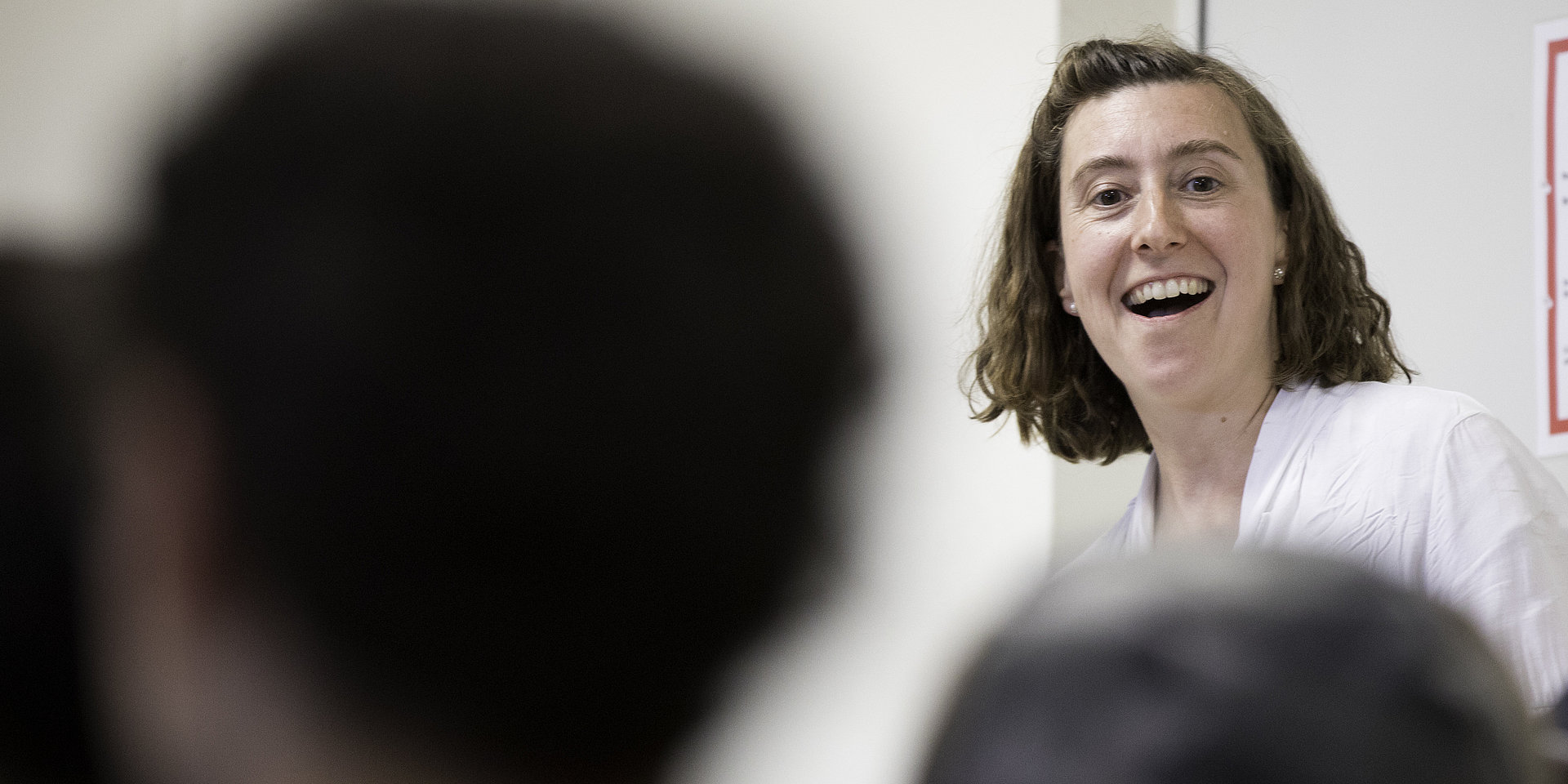 Professorin Hubrich steht breit lächelnd vor einer Gruppe von Kindern
