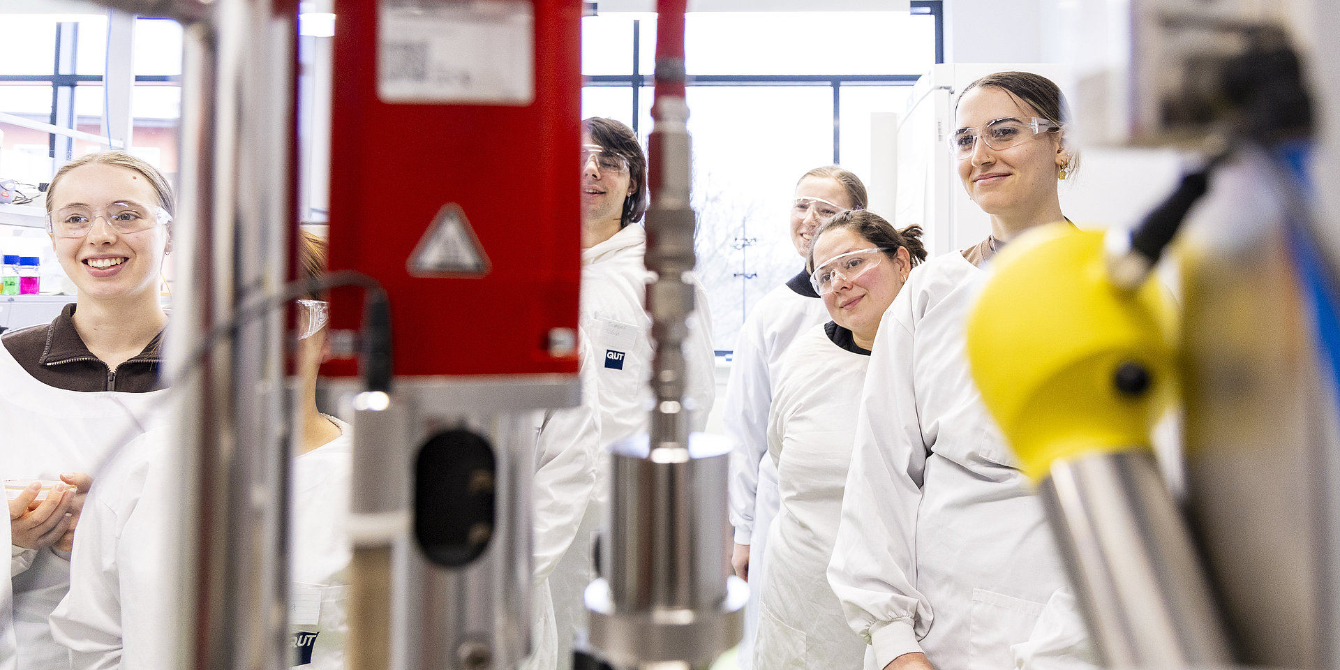 Studierende im Labor mit Schutzausrüstung.