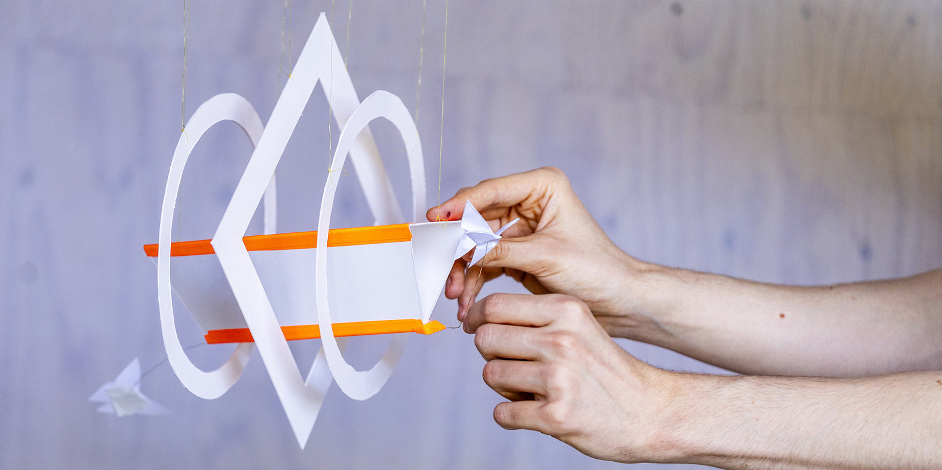 A hand is holding a paper spiral design.