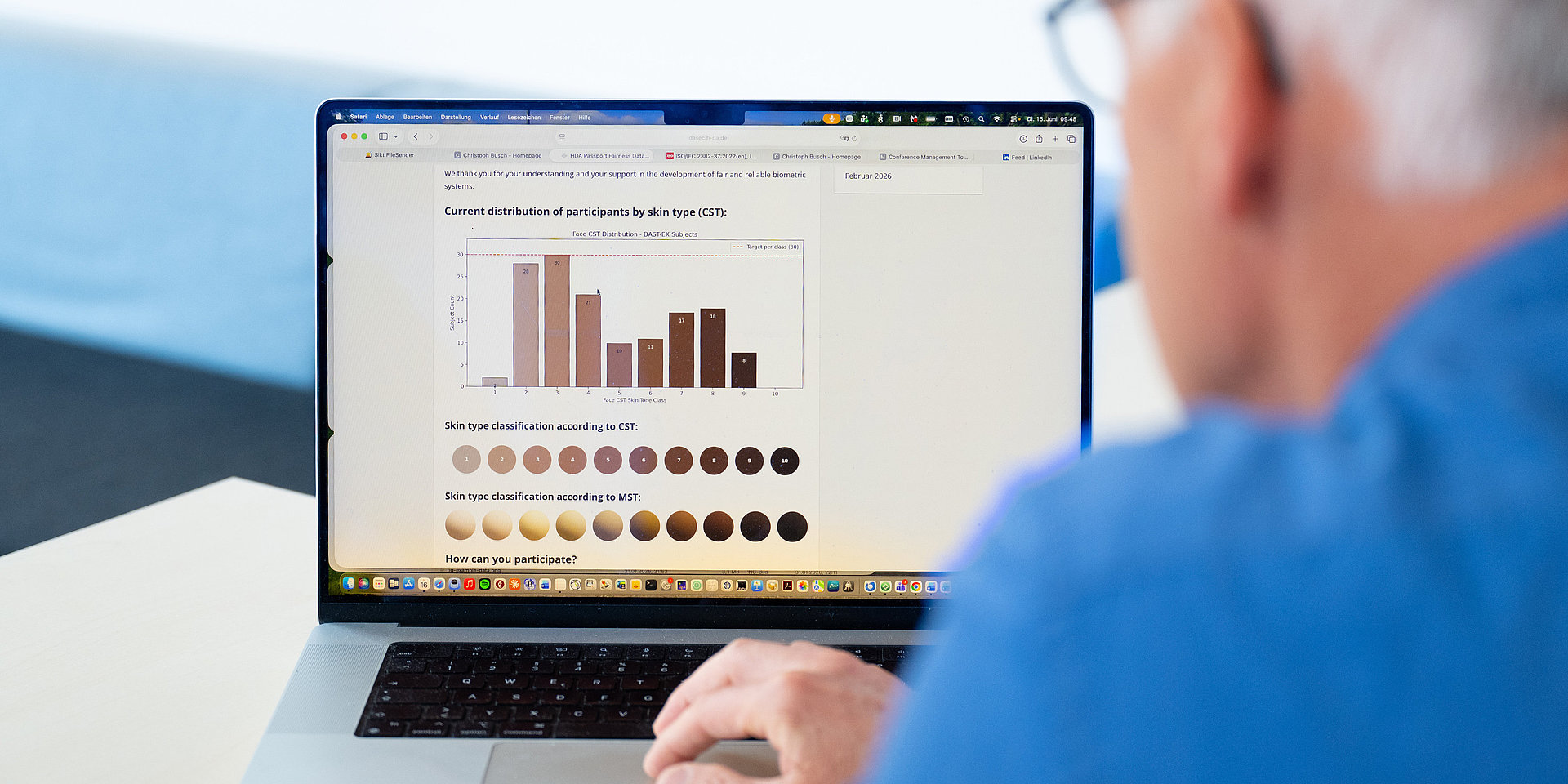 Christoph Busch reviews a bar chart on the laptop showing lighter and darker skin tones.