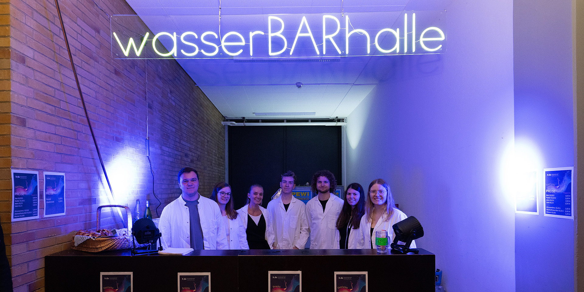 Studierende am Tresen mit dem Namen "WasserBARhalle".