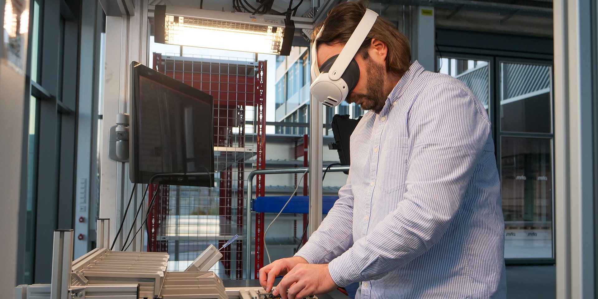 Fabian Sturm mit VR-Brille bei der Montage an einer Werkbank.