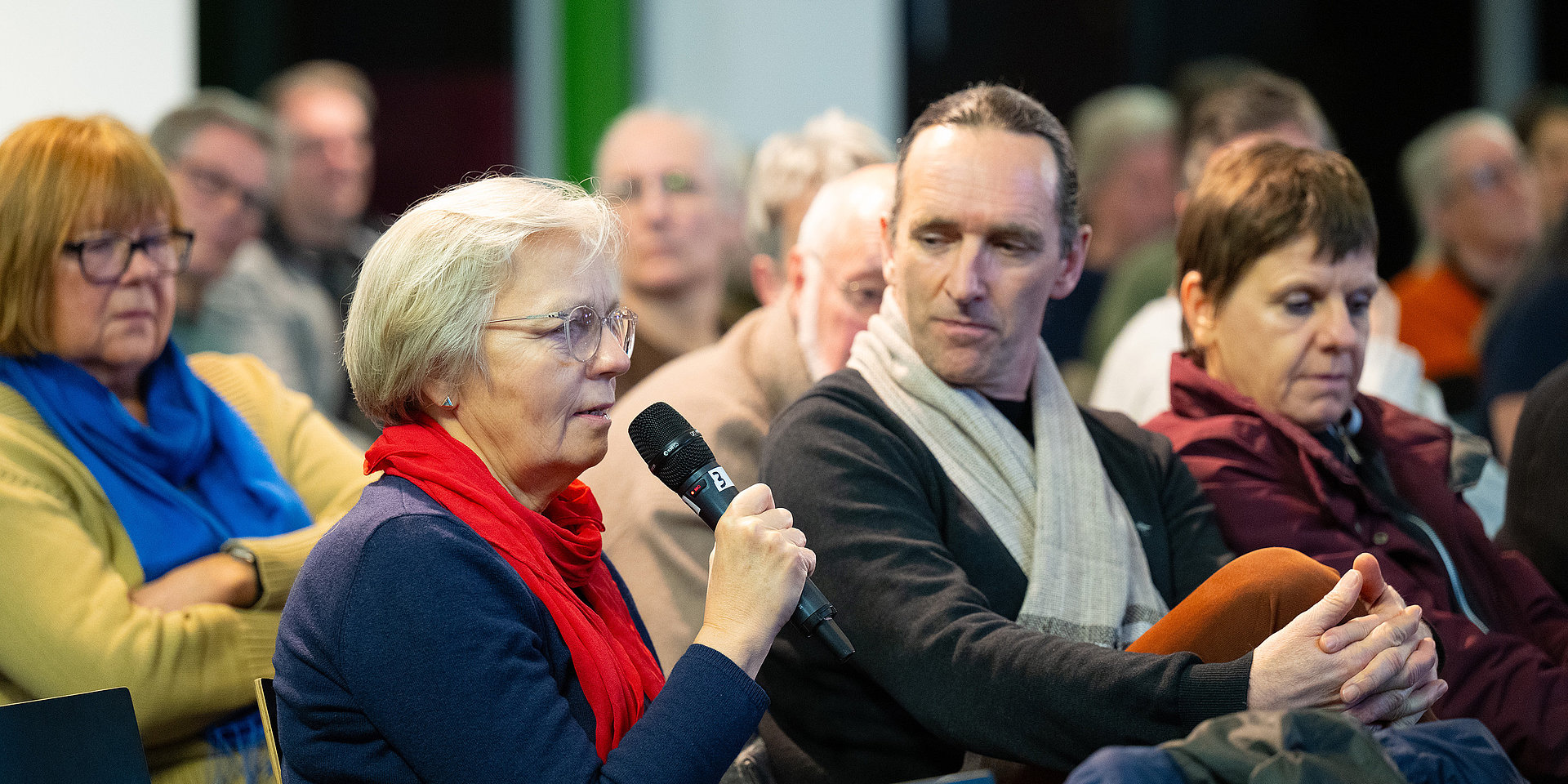 Eine Besucherin richtet eine Frage an das Podium.
