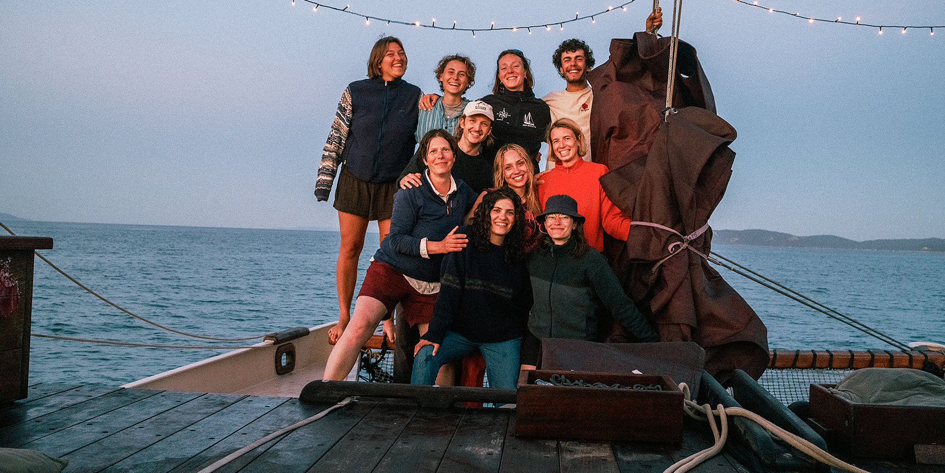 A group of five students and their professor on a boat.