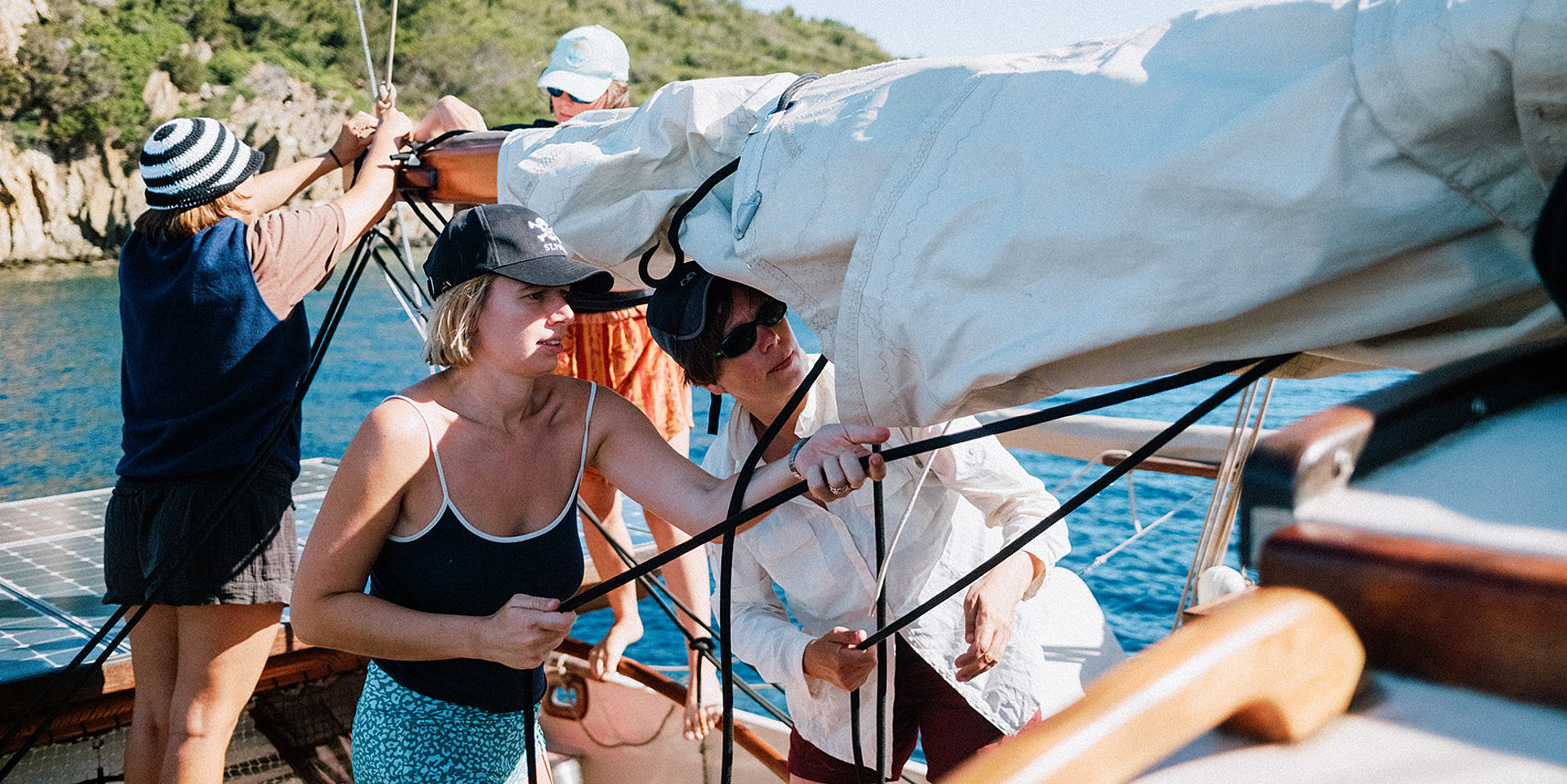 Professorin und Studentin stehen nebeneinander auf einem Segelboot.