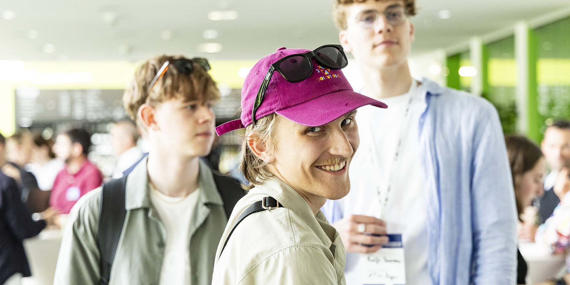 Eine Nahaufnahme eines Studenten mit einer leuchtend pinkfarbenen Kappe.