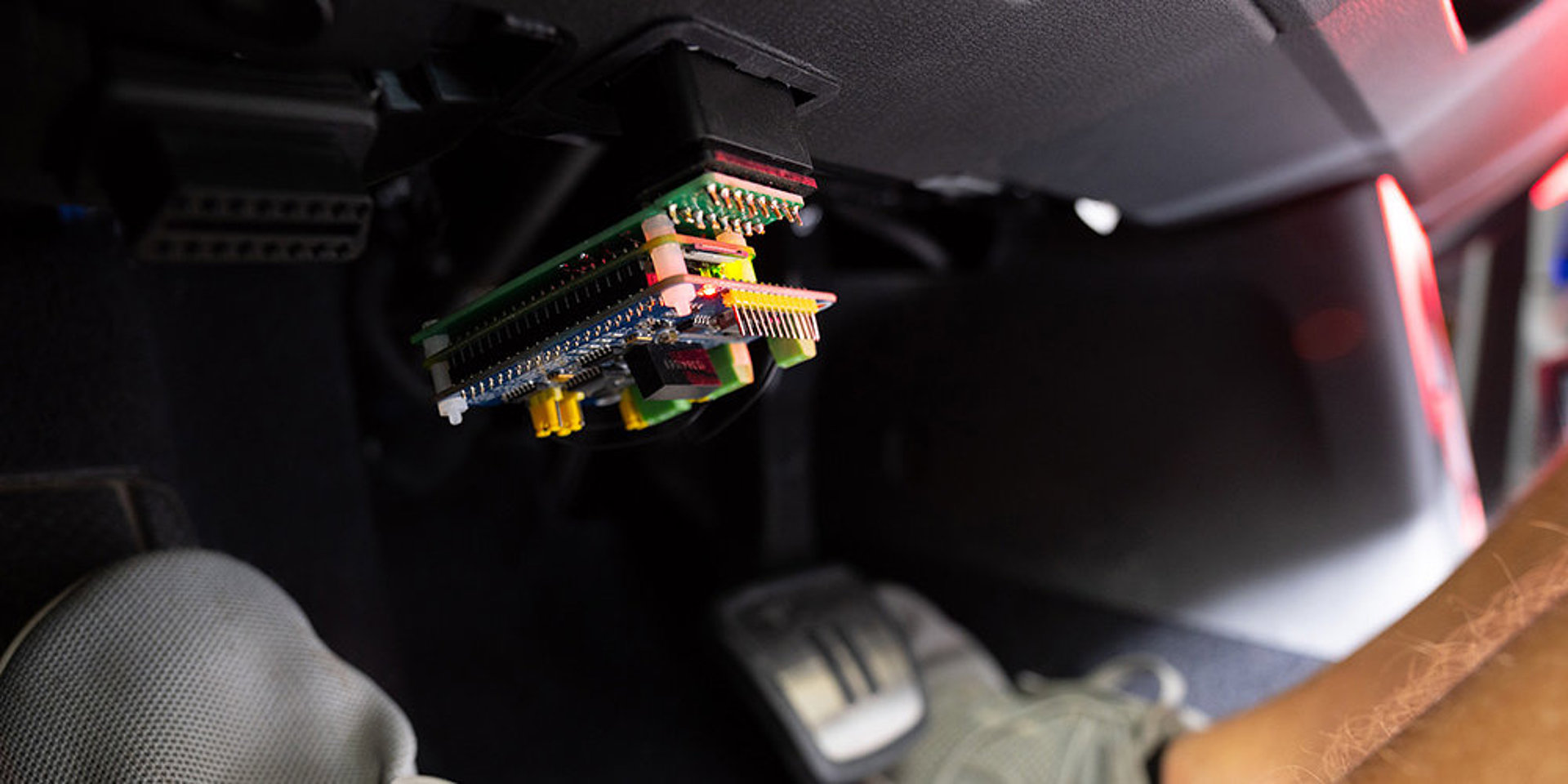 Der Raspberry Pi mit einem Adapter im Analysesteckplatz im Fußraum des Autos. 