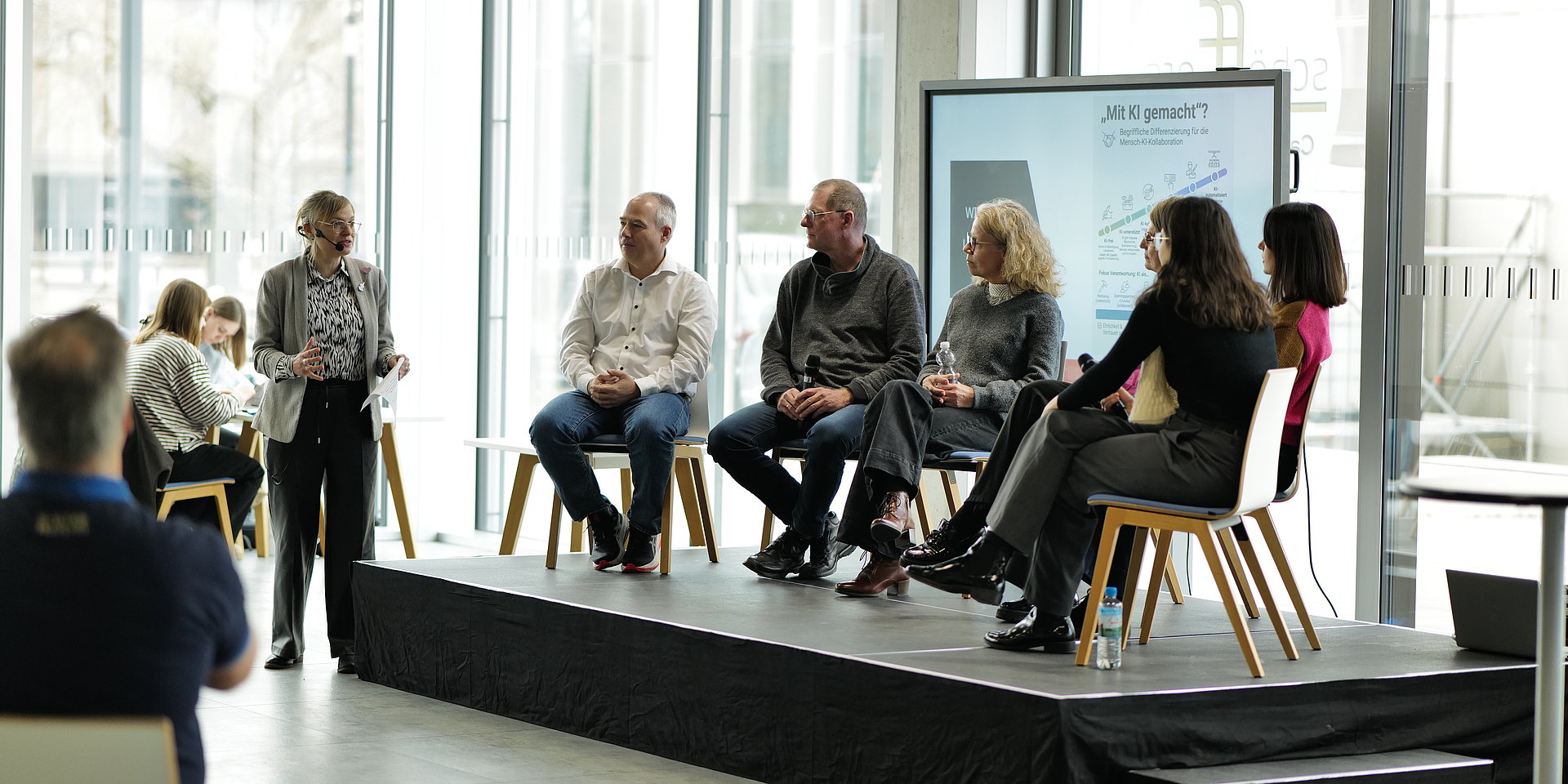 Diskussionsteilnehmende bei einer Konferenz im Studierendenhaus der h_da auf dem Podium.