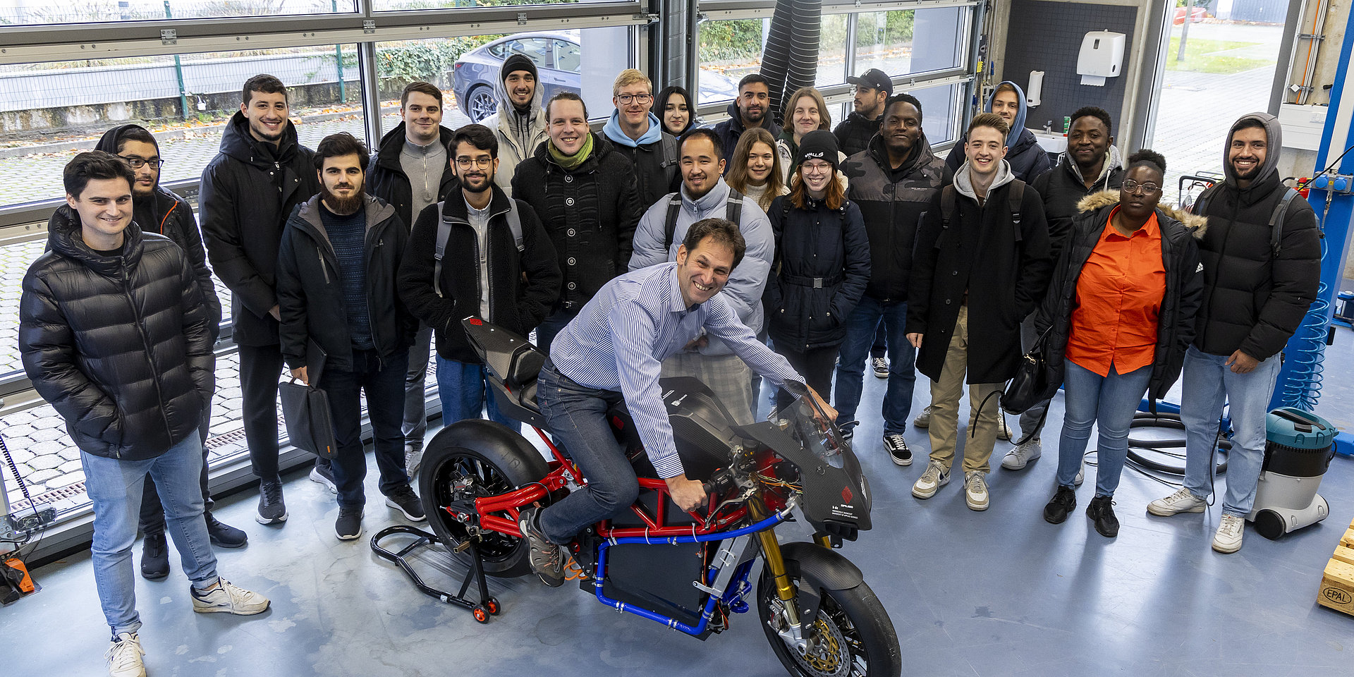 Jens Hoffmann am Elektro-Motorrad mit einem interdisziplinären Studierenden-Team.