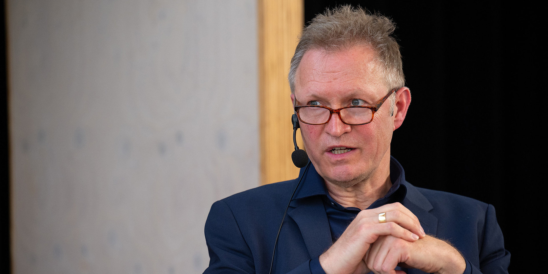 Moderator Thomas Döring stellt eine Frage und blickt die Adressatin an.