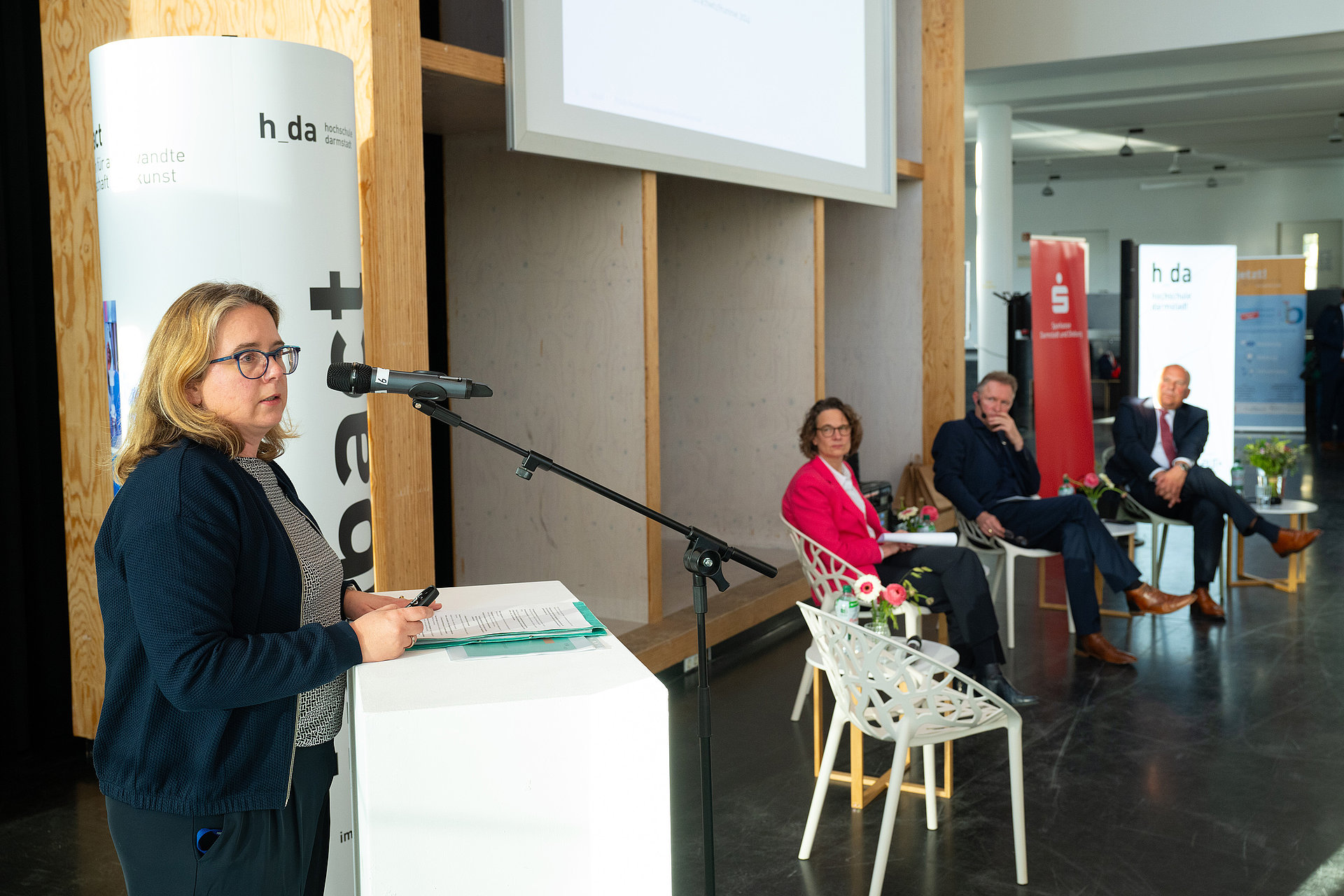 A view of Charlotte Dany from h_da delivering her short presentation on the podium.