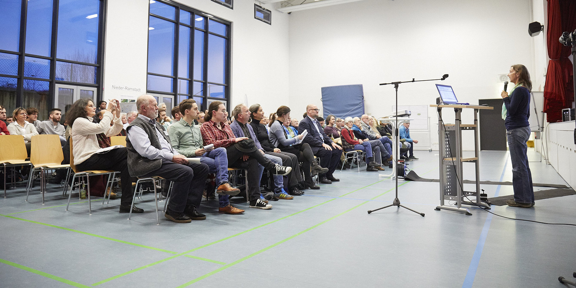 Bürgersaal mit gut gefüllten Stuhlreihen, vorne am Rednerpult eine der beiden Professorinnen