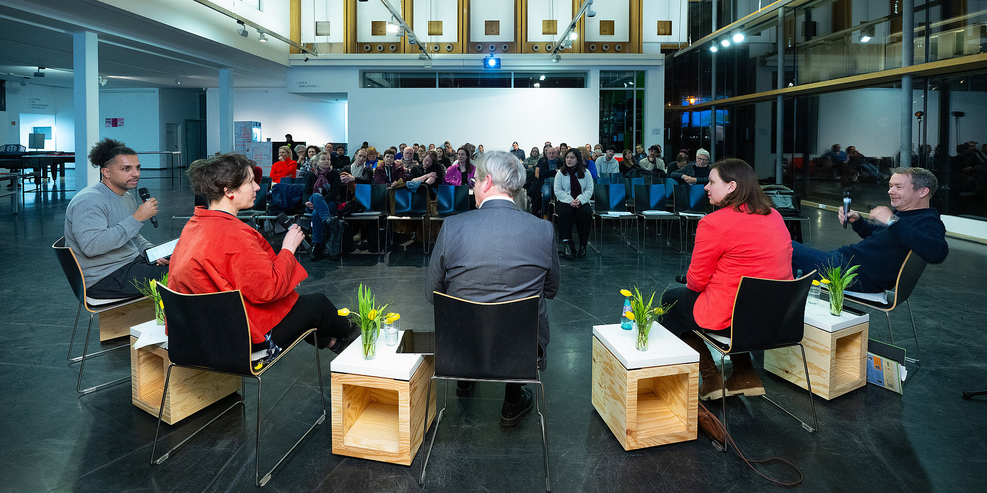 Die Panelisten im Vordergrund, das Publikum im Hintergrund.