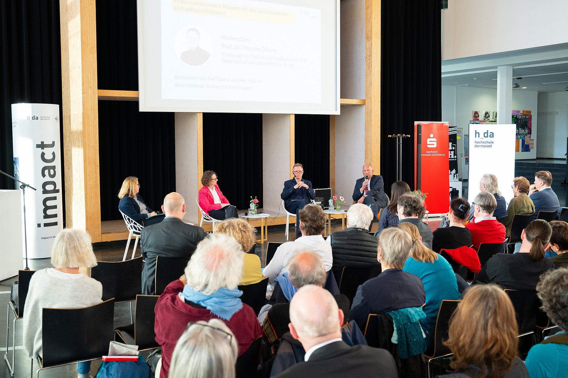 The speakers and moderator Thomas Döring have taken their seats on the panel.