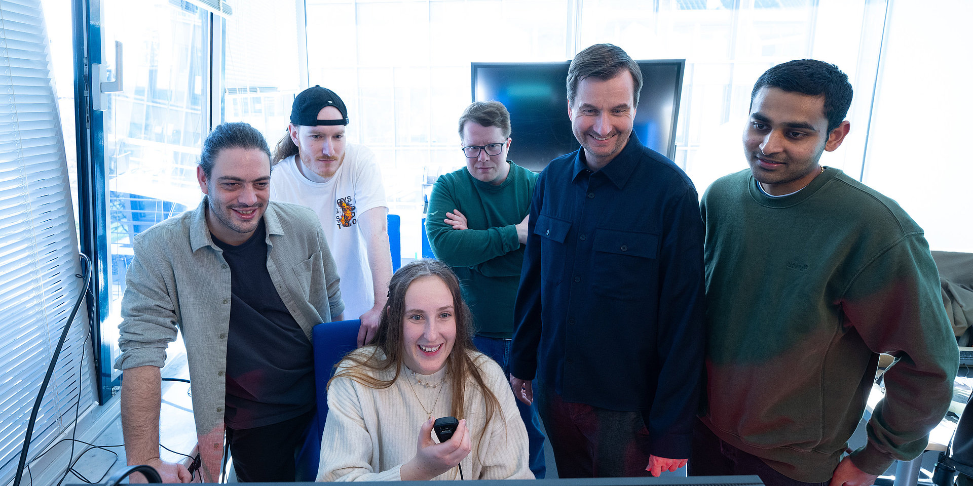 Gruppe der BIP-Beteiligten steht vor einem Computerbildschirm und setzt einen Funkspruch ab. 