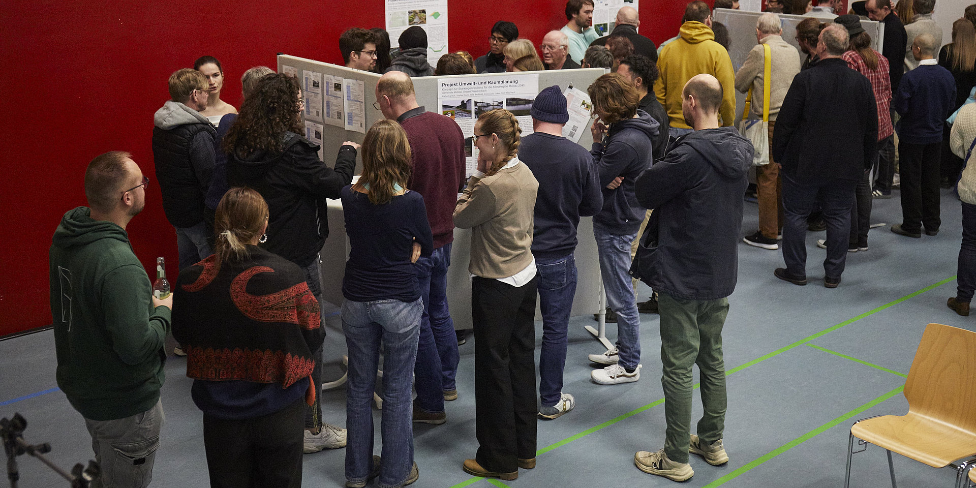 Viele Menschen stehen bei der Bürgerversammlung zum Thema Starkregen in Frankenhausen um die Präsentationswände von h_da-Studierenden herum und diskutieren