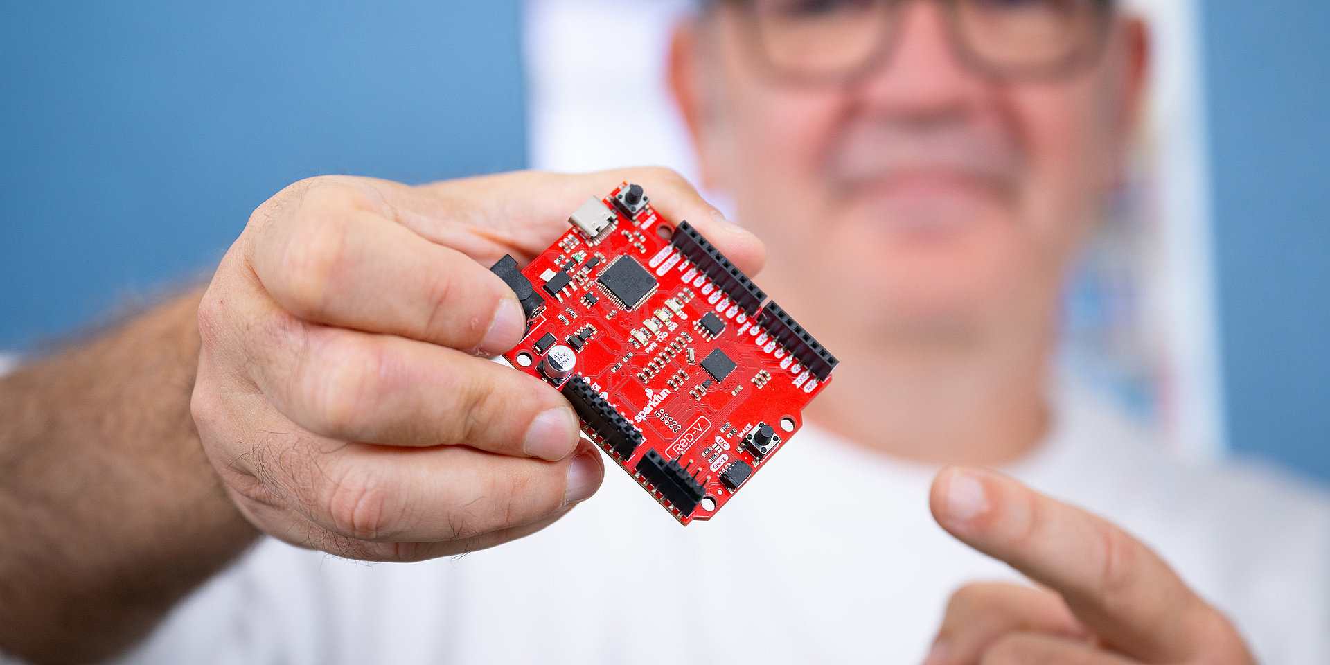 Prof. Campos is holding up a RISC-V board.