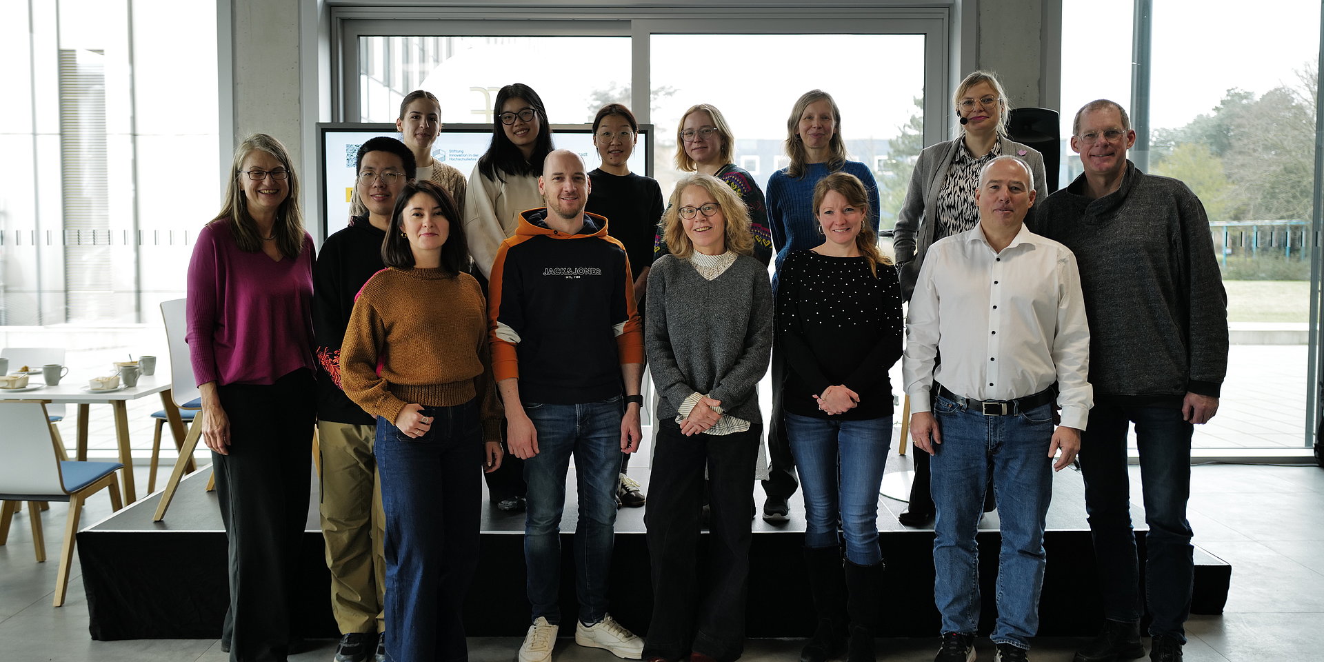 Team von 14 Personen, die in die Kamera schauen.